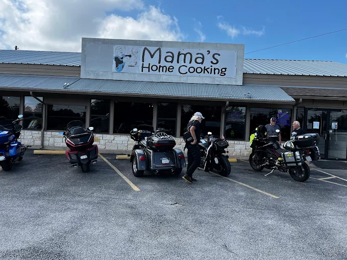 Exterior of Mama's Home Cooking restaurant with several motorcycles parked in front and customers entering the building.